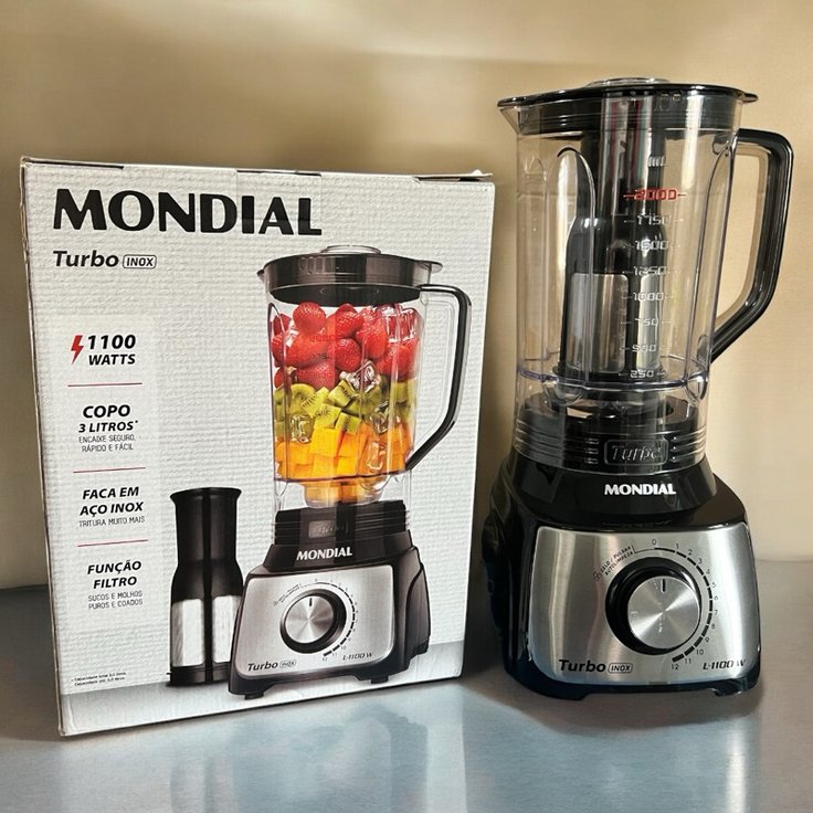 Liquidificador Mondial Turbo Inox 1100 W ao lado da caixa